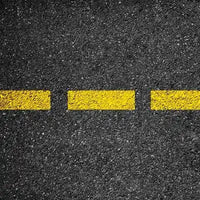 An asphalt road representing heavy-civil construction, where C-Block skid steer tracks provide excellent cut resistance for demolition and road-building.