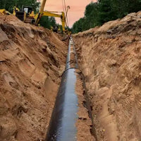 A freshly dug trench, illustrating an underground utility worksite where C-Block skid steer tracks provide precision control for infrastructure projects.