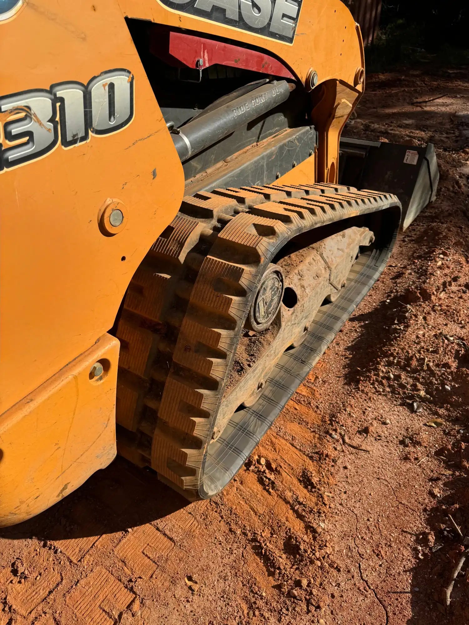 Orange construction vehicle with a track drive system.